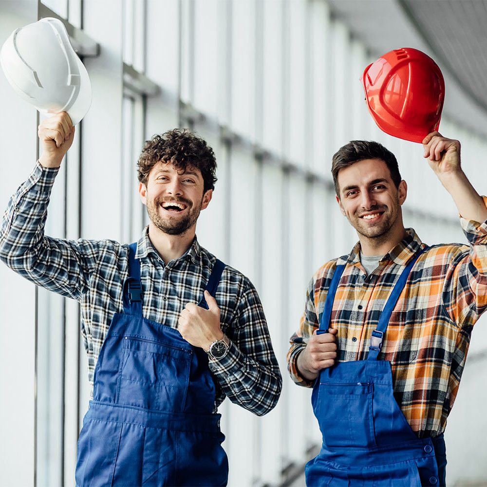 good-looking-construction-worker-sharing-with-experience-with-colleague-holding-helmet