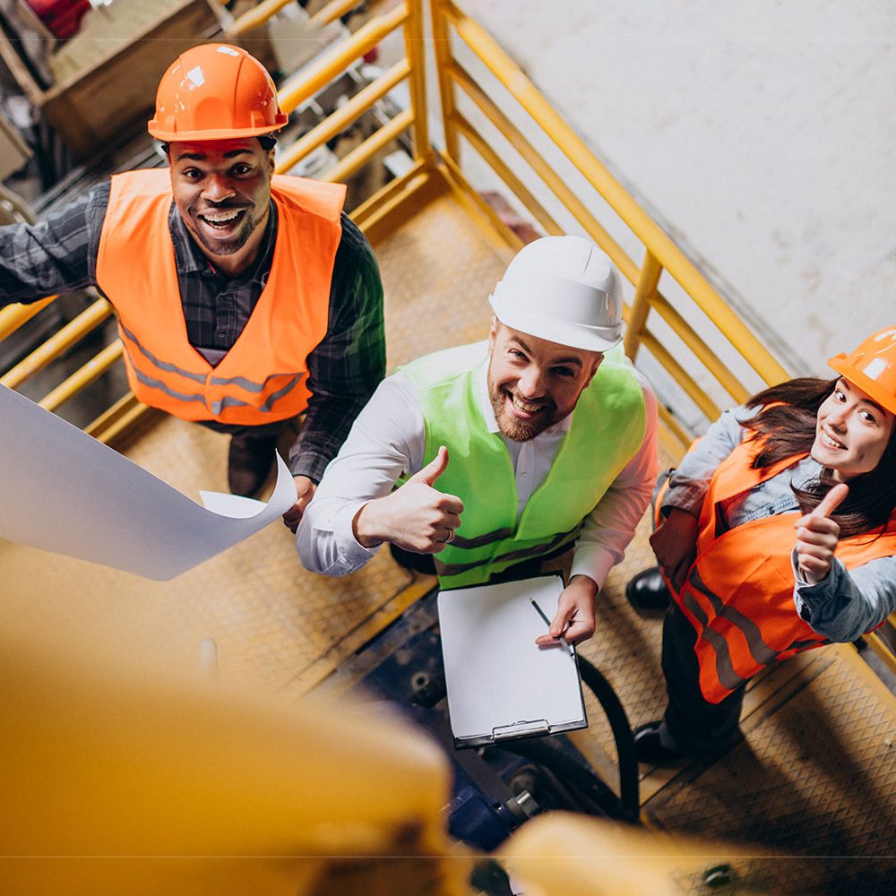 three-factory-workers-safety-hats-discussing-manufacture-plan