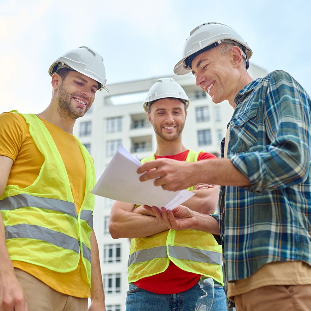 three-men-with-drawing-discussing-construction-site